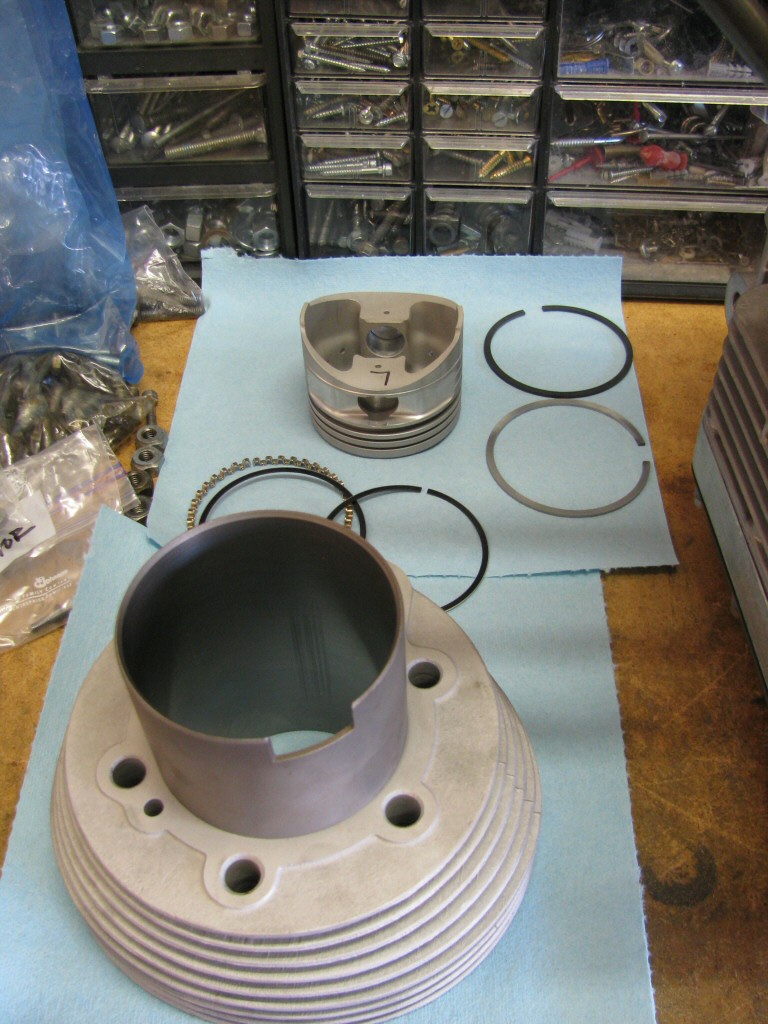 The left cylinder, piston, rings, wrist pin, and circlips.