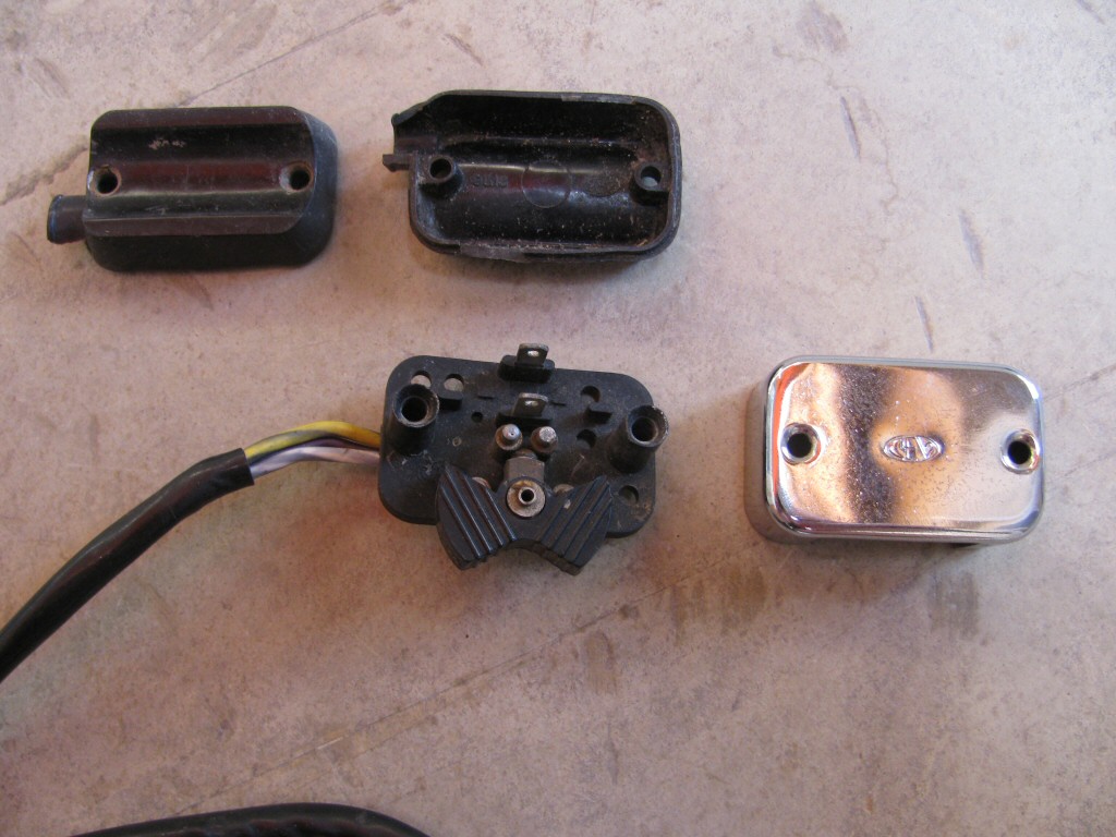 Right handlebar switch for actuating the turn signals (MG# 12750301). Also shown is both sides of the plastic piece that fits between the switch and the brake lever perch.