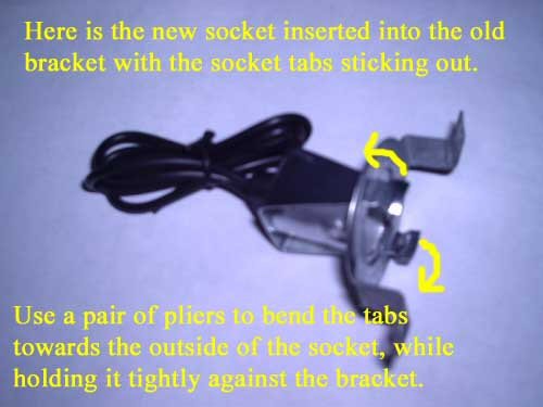 Here is the new socket inserted into the old bracket with the socket tabs sticking out. Use a pair of pliers to bend the tabs towards the outside of the socket, while holding it tightly against the bracket.