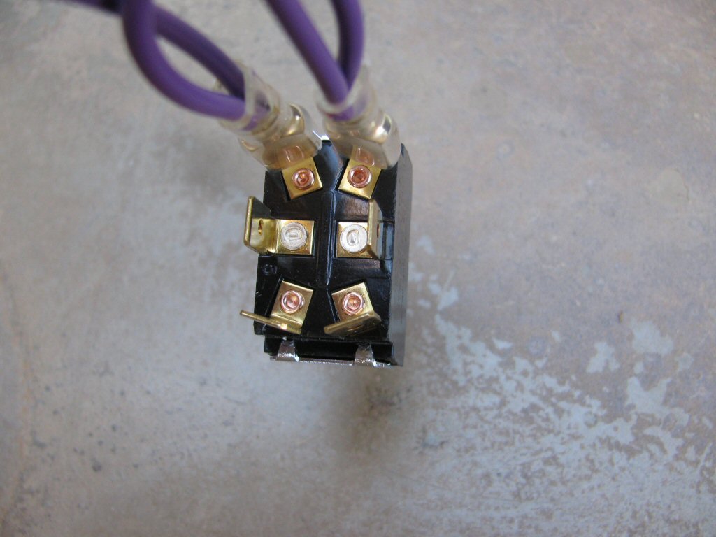 The two purple wires from the main harness are connected to the two terminals on one end of the toggle switch (it does not matter which end).