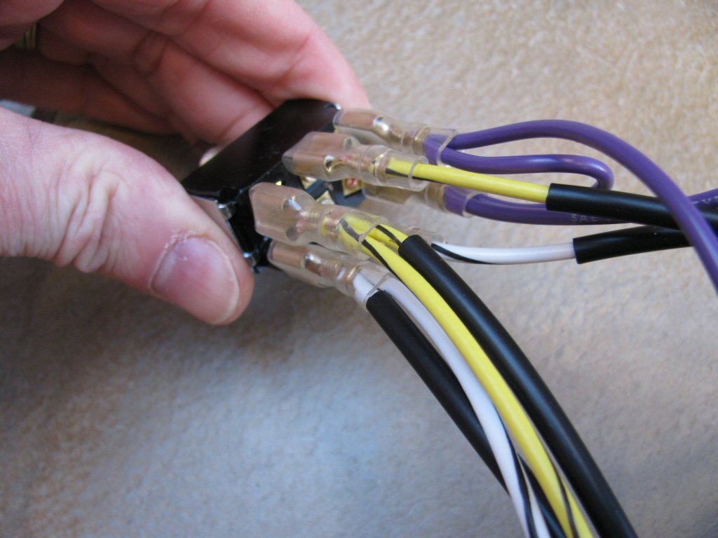 The white/black and yellow/black wires from the turn signal switch are connected to the two terminals on the opposite end of purple wires on toggle switch. Note how the yellow/black wires are on the same side.