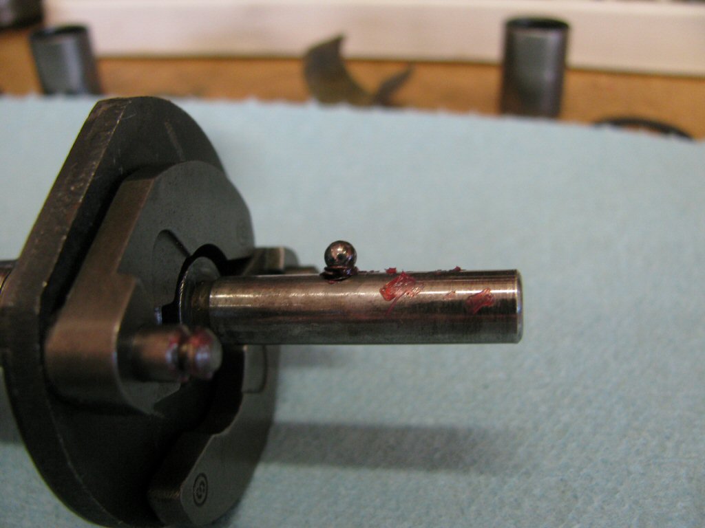 Place a dab of grease on the tiny ball bearing and place it onto the spring.