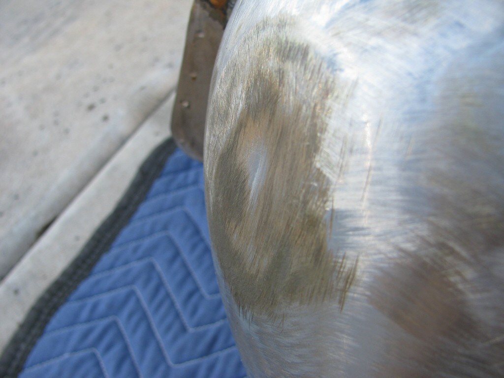 Gas tank stripped of paint. Same dent on left side of tank.