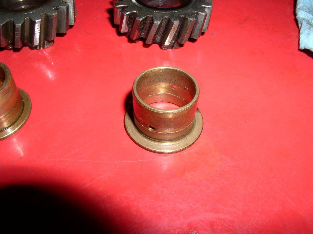 The early bushing has a shallow groove inside and out with two radial holes.